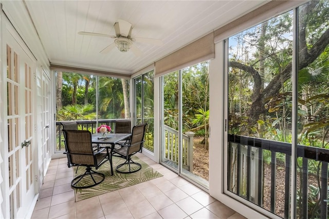 sunroom / solarium featuring outdoor dining area and a ceiling fan