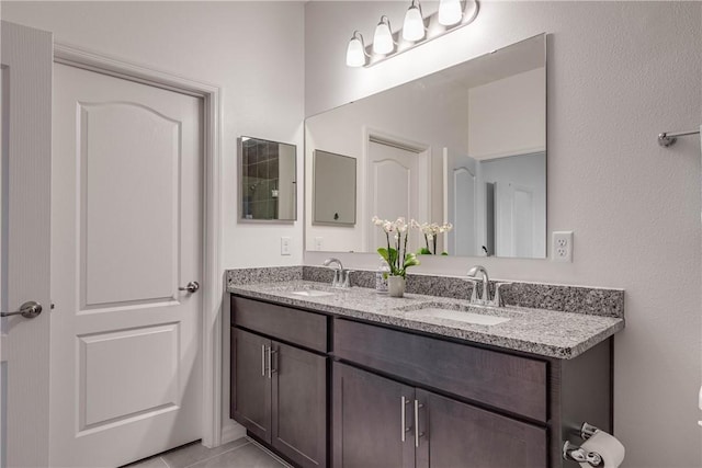 full bath with a sink, tile patterned floors, and double vanity