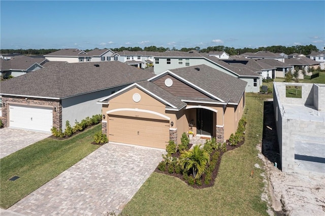 ranch-style home featuring a garage, stucco siding, stone siding, and a residential view