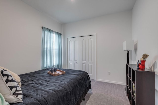 carpeted bedroom with baseboards and a closet