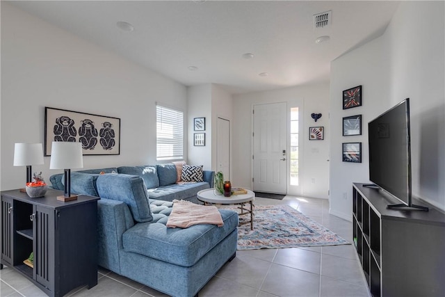 living area featuring visible vents and light tile patterned flooring