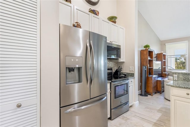 4877 N Newport Island Dr Unit 14D, Vero Beach, FL 32967 - kitchen with stainless steel appliances, tasteful backsplash, lofted ceiling, light stone countertops, and white cabinetry