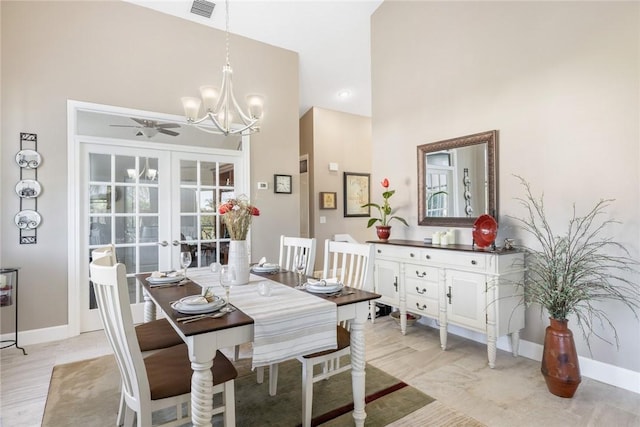 dining room featuring ceiling fan with notable chandelier and french doors