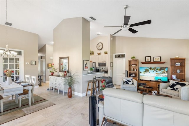 living room featuring ceiling fan with notable chandelier, high vaulted ceiling, and light hardwood / wood-style flooring