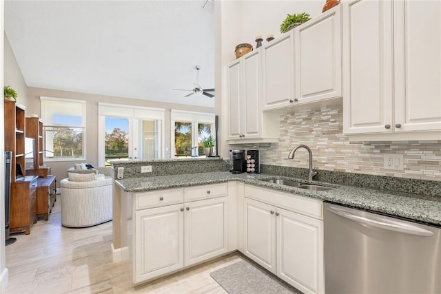 kitchen with kitchen peninsula, white cabinetry, stainless steel dishwasher, and sink