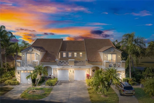 4877 N Newport Island Dr Unit 14D, Vero Beach, FL 32967 - mediterranean / spanish-style house with a balcony, a garage, concrete driveway, stucco siding, and a tile roof