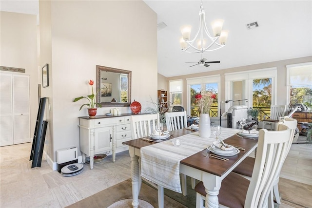 dining area with high vaulted ceiling and ceiling fan with notable chandelier