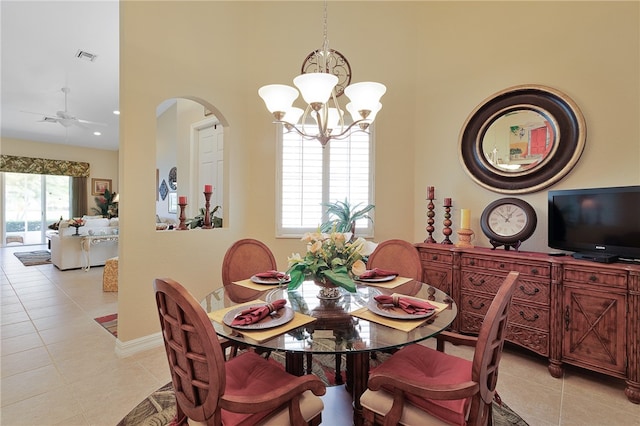 tiled dining room featuring ceiling fan with notable chandelier