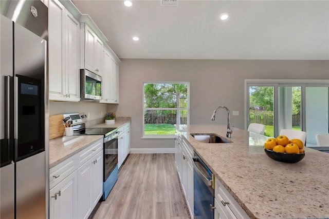 11126 Roseland Rd, Sebastian, FL 32958 - kitchen with white cabinets, a healthy amount of sunlight, stainless steel appliances, and a sink