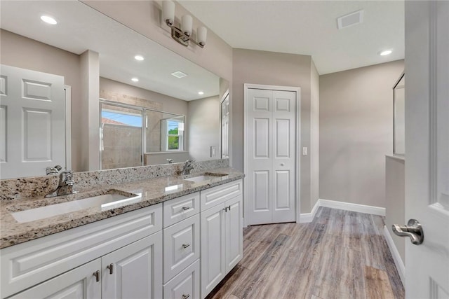 11126 Roseland Rd, Sebastian, FL 32958 - bathroom with wood finished floors, visible vents, a sink, and a shower stall