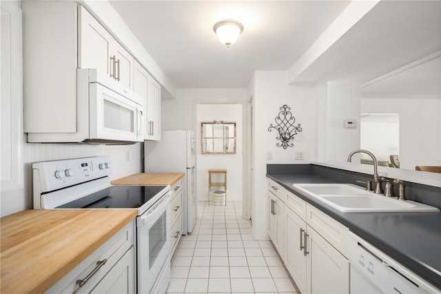 kitchen featuring white cabinets, white appliances, sink, and light tile patterned floors