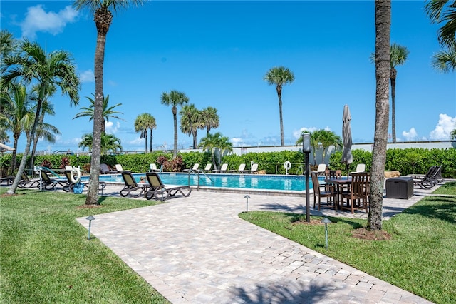 view of pool with a lawn and a patio