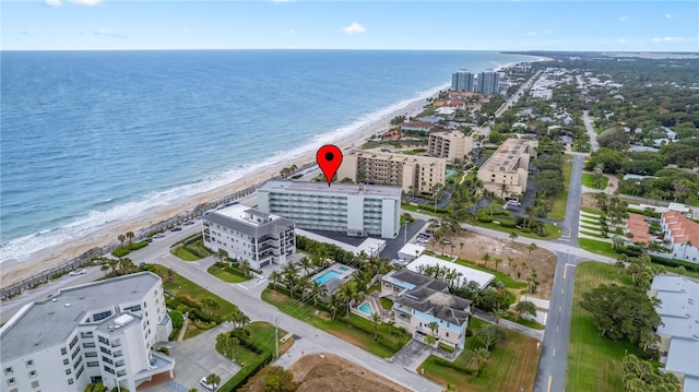 birds eye view of property with a water view and a beach view