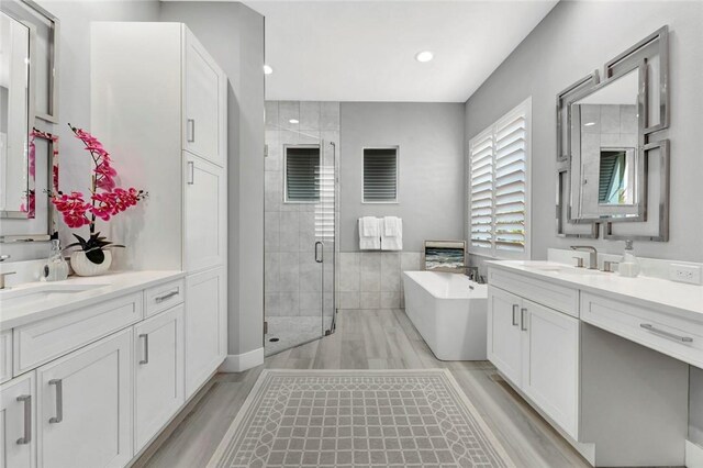 9378 Orchid Cove Cir, Vero Beach, FL 32963 - bathroom with a soaking tub, a stall shower, two vanities, and a sink