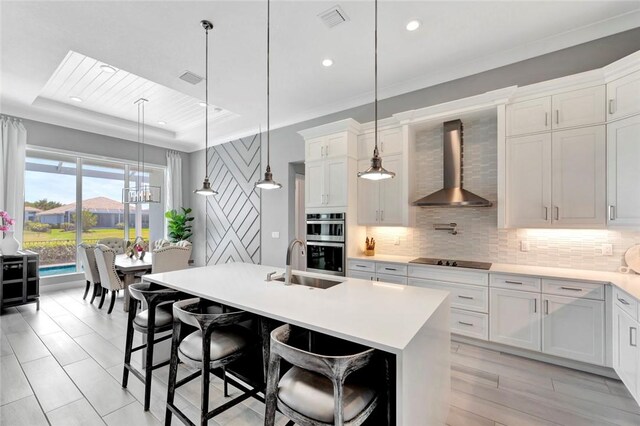 9378 Orchid Cove Cir, Vero Beach, FL 32963 - kitchen with decorative backsplash, stainless steel double oven, wall chimney range hood, and visible vents
