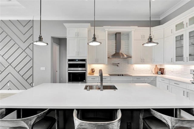 9378 Orchid Cove Cir, Vero Beach, FL 32963 - kitchen with wall chimney range hood, decorative backsplash, a sink, stainless steel double oven, and black electric cooktop