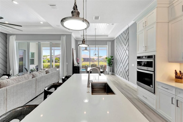 9378 Orchid Cove Cir, Vero Beach, FL 32963 - kitchen with double oven, a sink, light countertops, a tray ceiling, and open floor plan