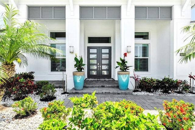 9378 Orchid Cove Cir, Vero Beach, FL 32963 - entrance to property featuring a porch, stucco siding, and french doors