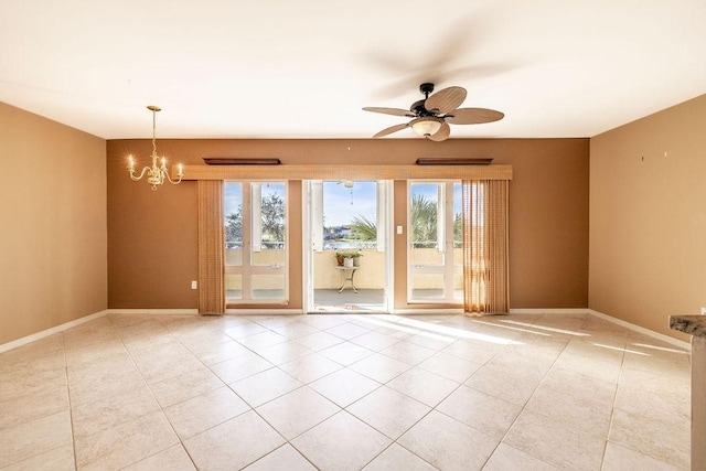 tiled spare room featuring ceiling fan with notable chandelier