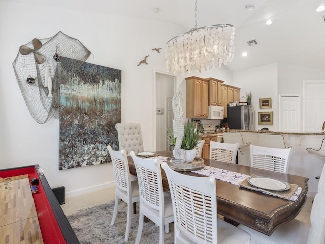 dining space with lofted ceiling and a chandelier