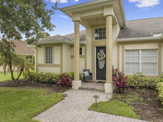 view of exterior entry with a yard