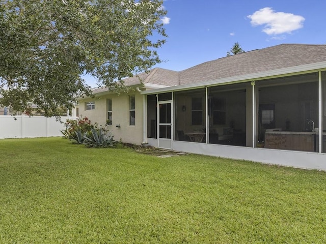 rear view of property featuring a sunroom and a lawn