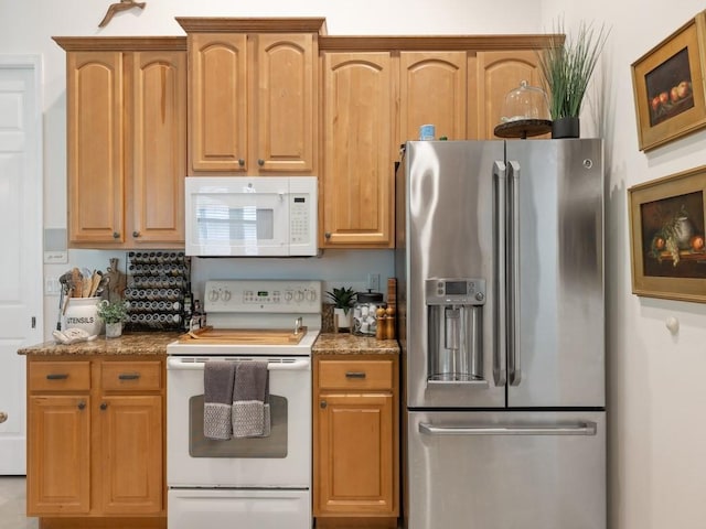 kitchen featuring light stone counters and white appliances