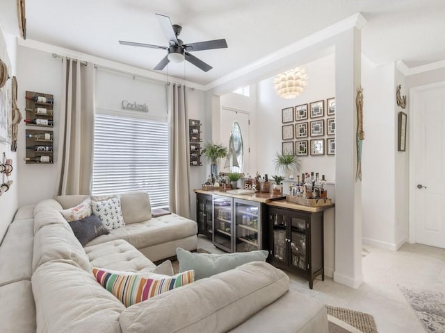 living room with ceiling fan, bar area, crown molding, and a healthy amount of sunlight