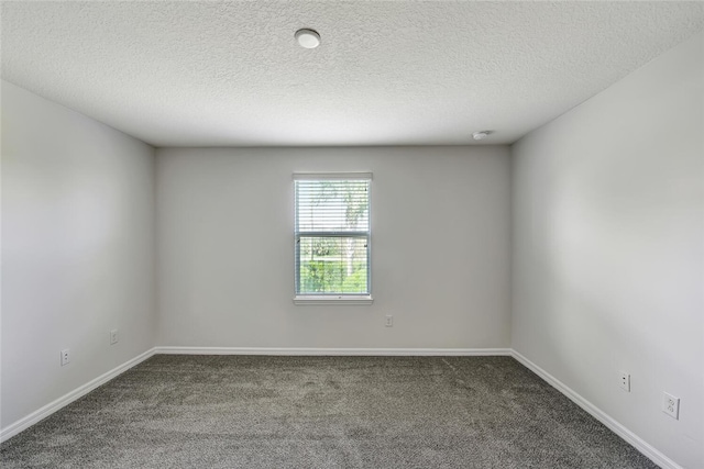 spare room featuring carpet floors and a textured ceiling