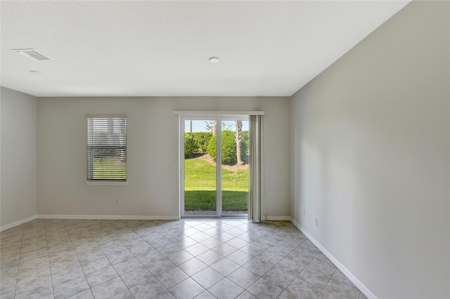spare room with light tile patterned flooring, baseboards, and visible vents