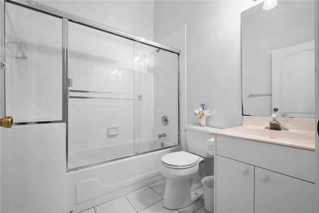 full bathroom featuring tile patterned floors, combined bath / shower with glass door, vanity, and toilet