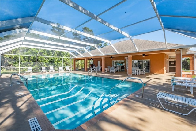 view of swimming pool featuring ceiling fan, a patio area, and glass enclosure