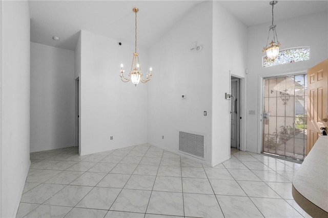 interior space with a towering ceiling and a chandelier