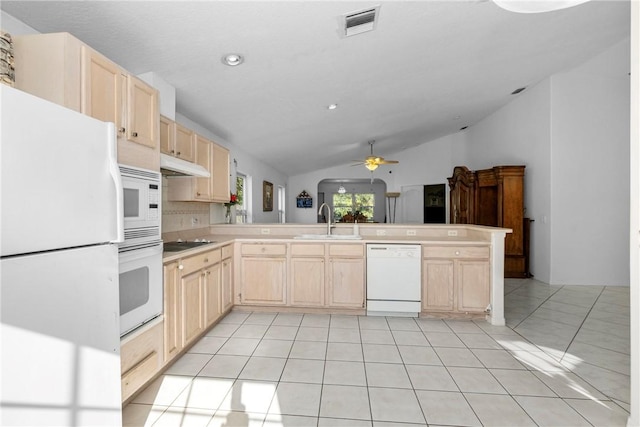 kitchen featuring kitchen peninsula, light brown cabinets, white appliances, vaulted ceiling, and sink