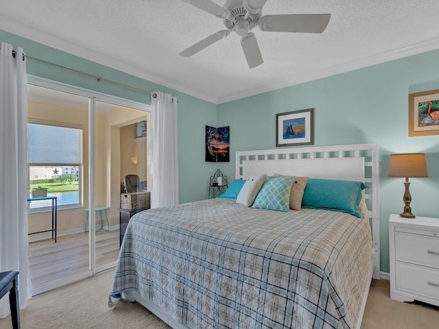 carpeted bedroom featuring a textured ceiling, ceiling fan, and crown molding