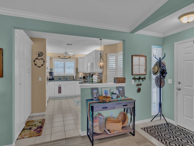 kitchen with a textured ceiling, decorative light fixtures, stainless steel electric range, crown molding, and white cabinets