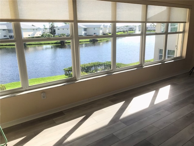 unfurnished sunroom featuring a water view