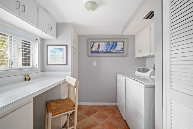 washroom featuring light tile patterned floors, washer and clothes dryer, and cabinets