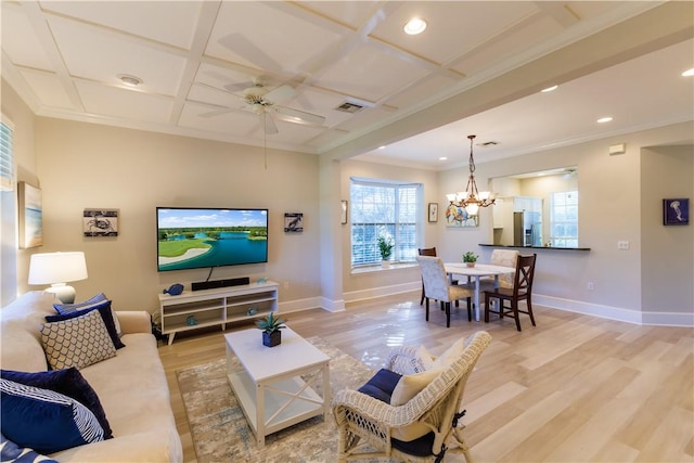 living room with ceiling fan with notable chandelier, light wood-type flooring, crown molding, and coffered ceiling