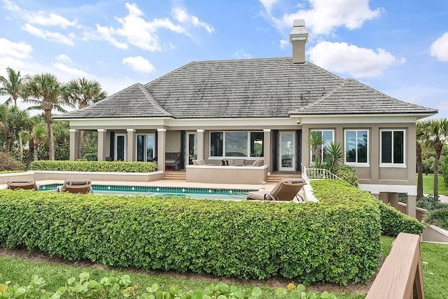 rear view of house with a fenced in pool