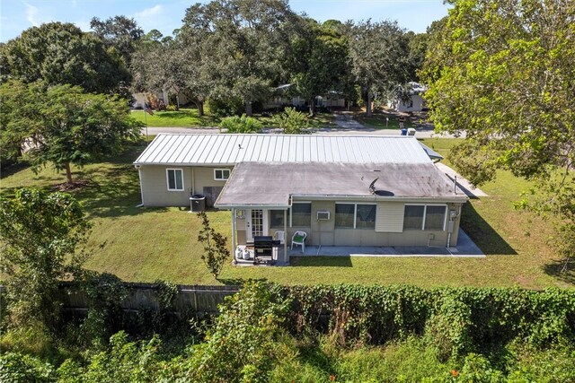 rear view of house featuring a yard and a patio