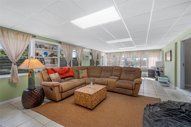 living room featuring light tile patterned floors and a paneled ceiling