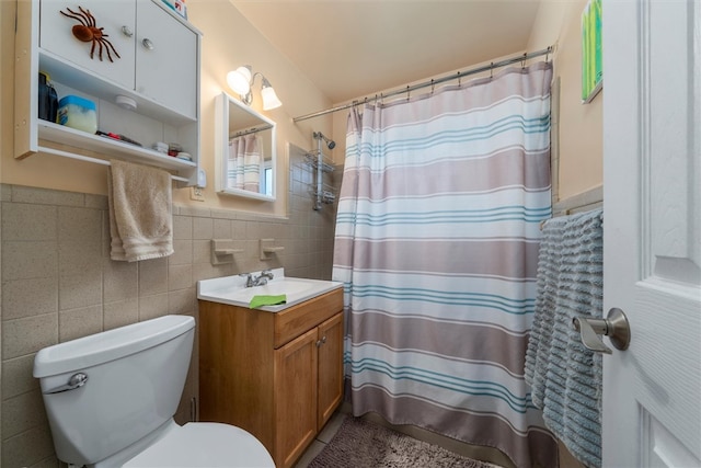 bathroom featuring curtained shower, vanity, tile walls, and toilet