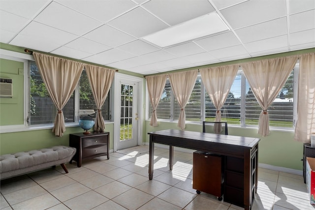 tiled office featuring a drop ceiling, a healthy amount of sunlight, and a wall mounted air conditioner