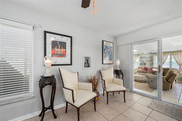 living area with ceiling fan and light tile patterned floors