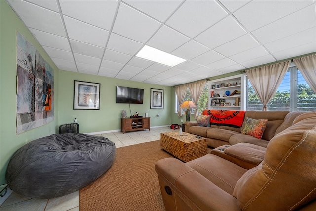 tiled living room featuring a drop ceiling