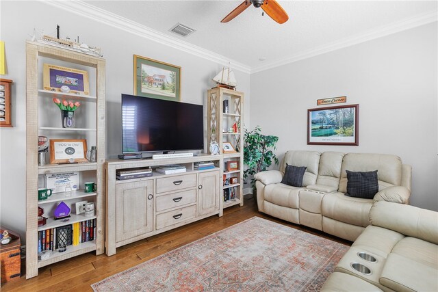 living room featuring ornamental molding, ceiling fan, a textured ceiling, and light hardwood / wood-style floors