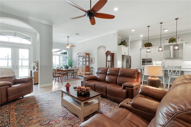 tiled living room featuring ceiling fan, french doors, and ornamental molding