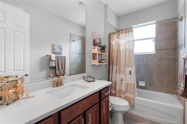 full bathroom featuring toilet, vanity, shower / bath combo with shower curtain, and tile patterned flooring