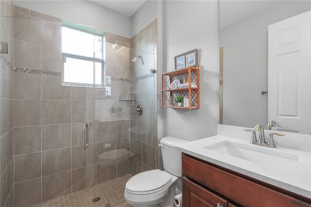 bathroom with toilet, vanity, and an enclosed shower